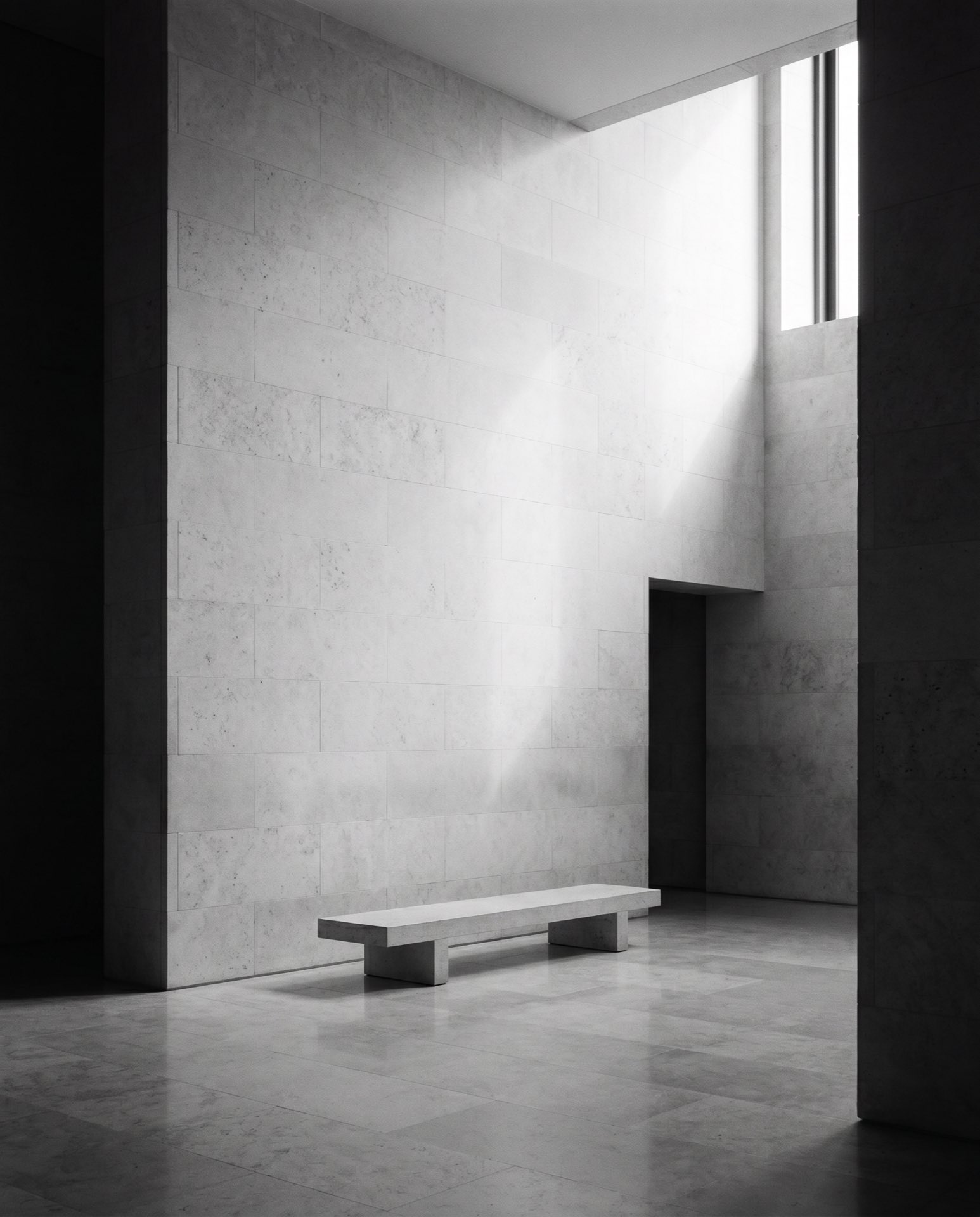 A double-height lobby in stone and low light